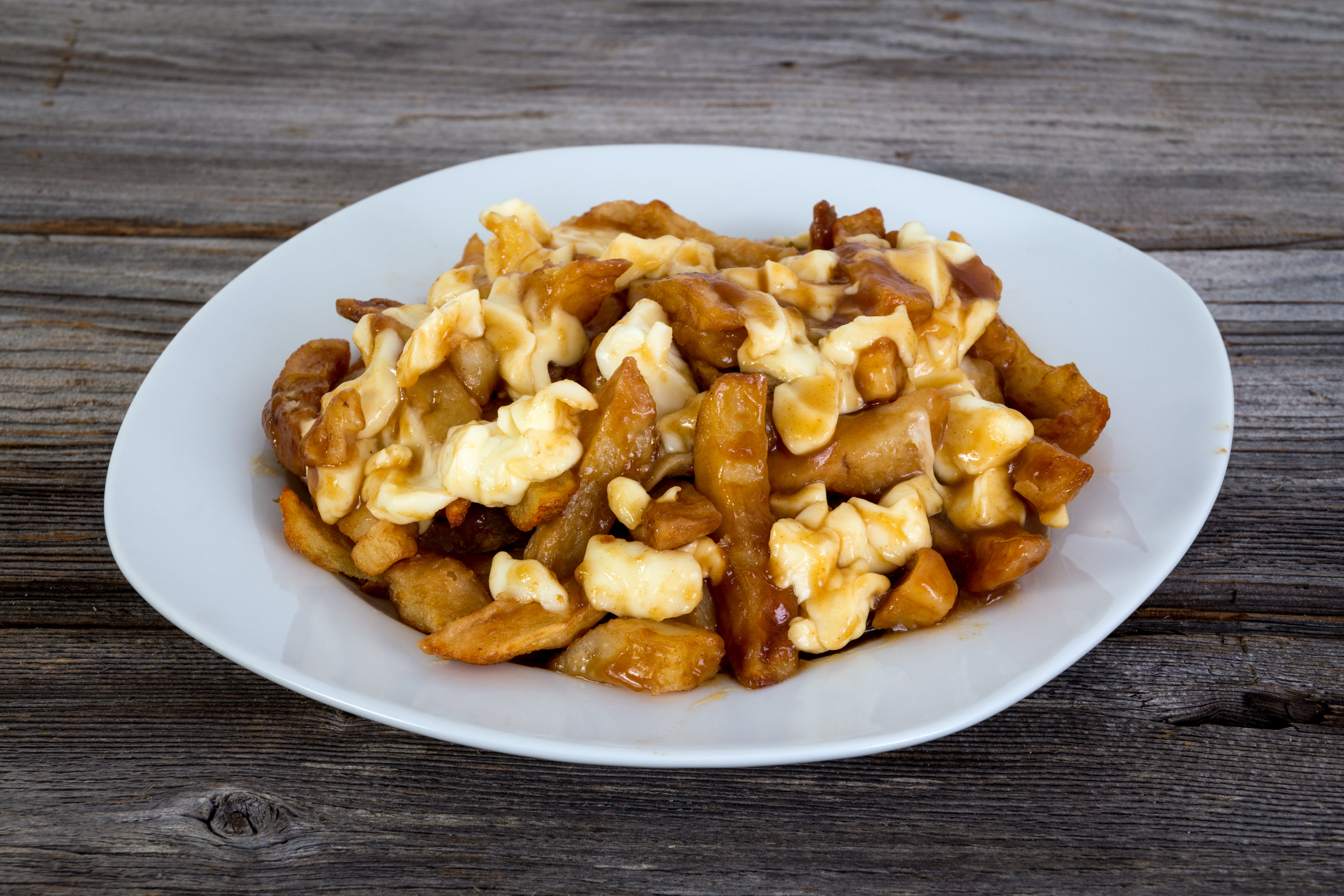 Plate of poutine with french fries gravy and cheese curds