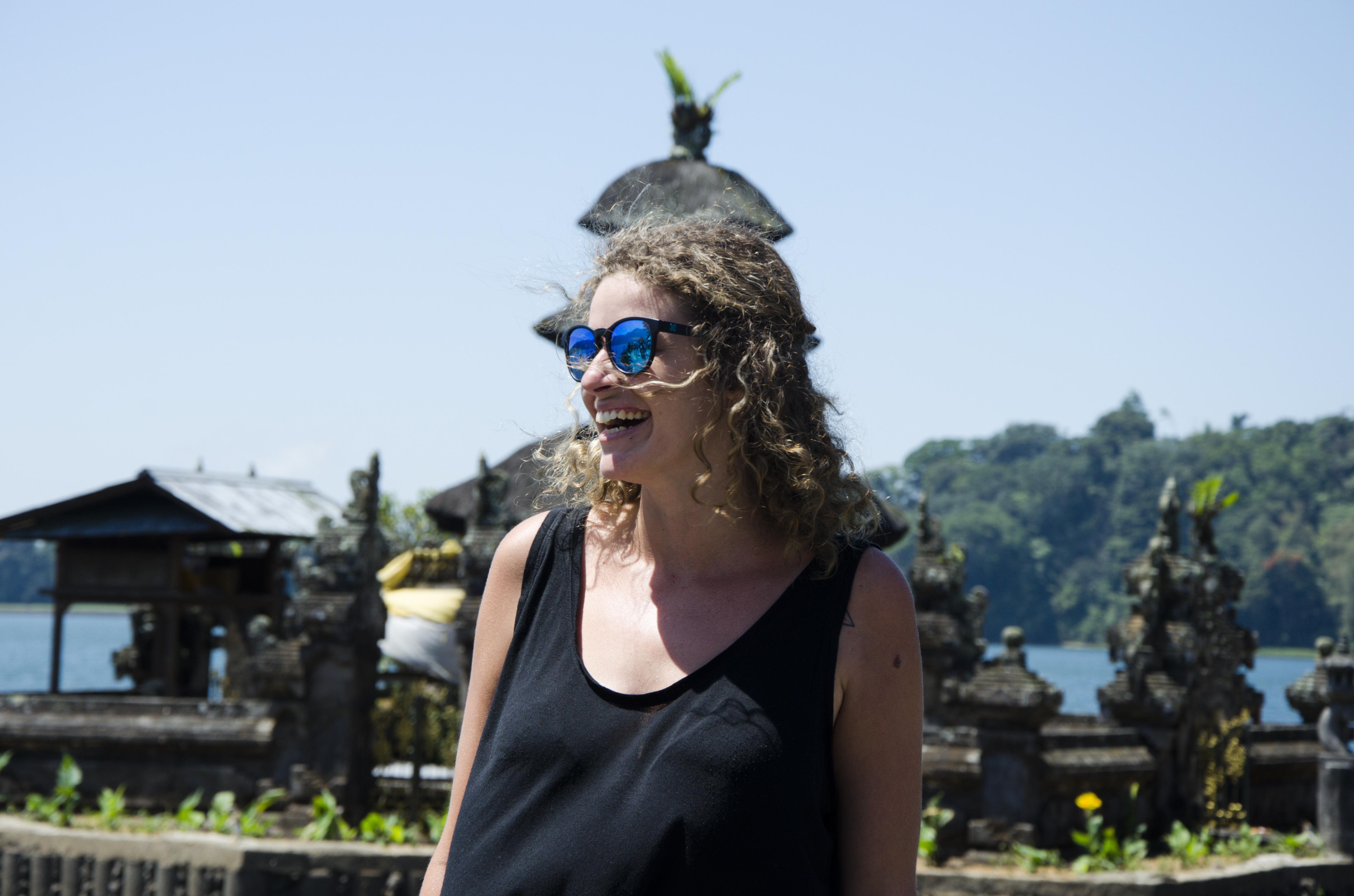 Young woman smiling while traveling in a tropical location.