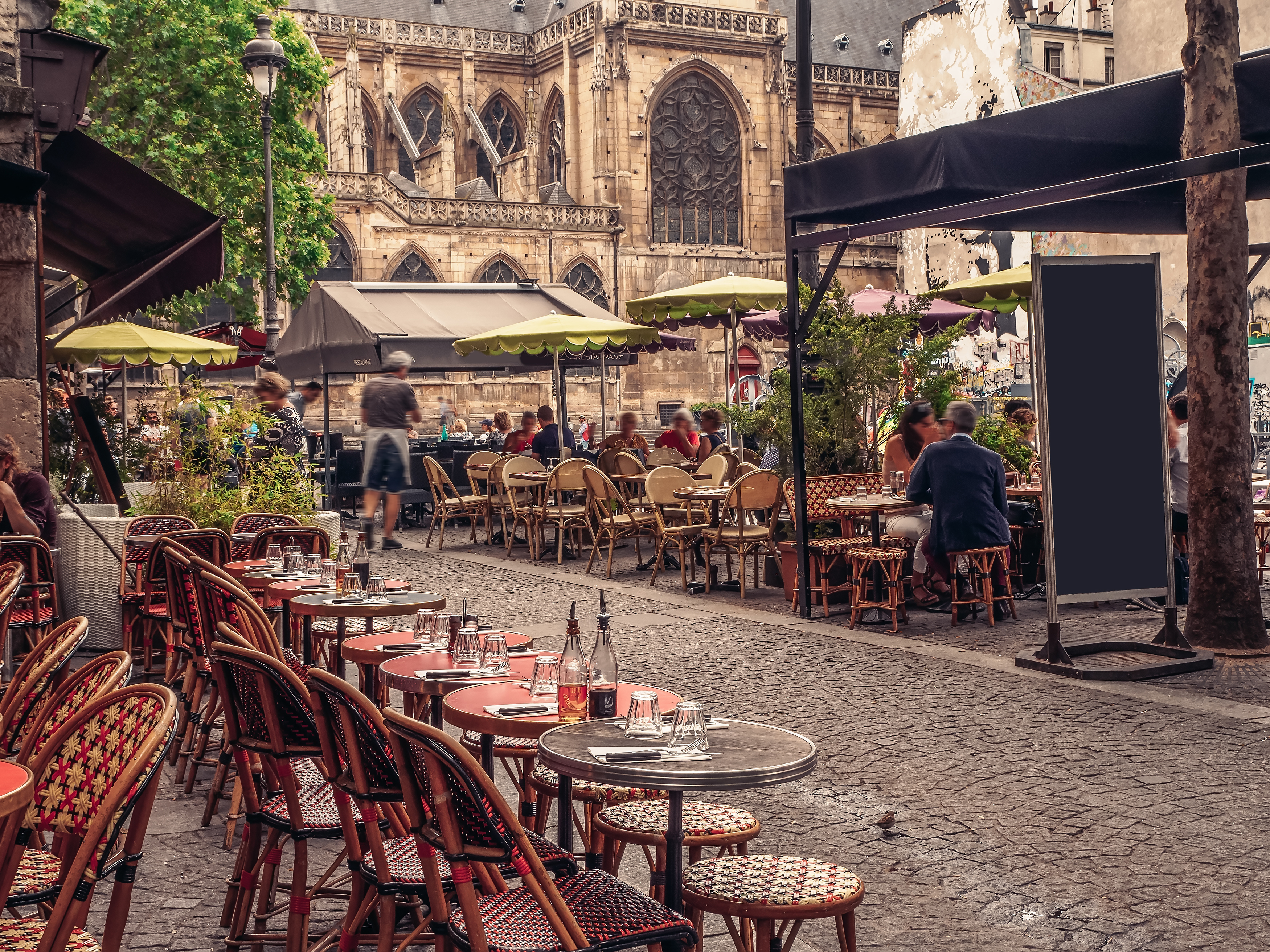 Cozy street with tables of cafe in Paris, France. Architecture and landmarks of Paris.