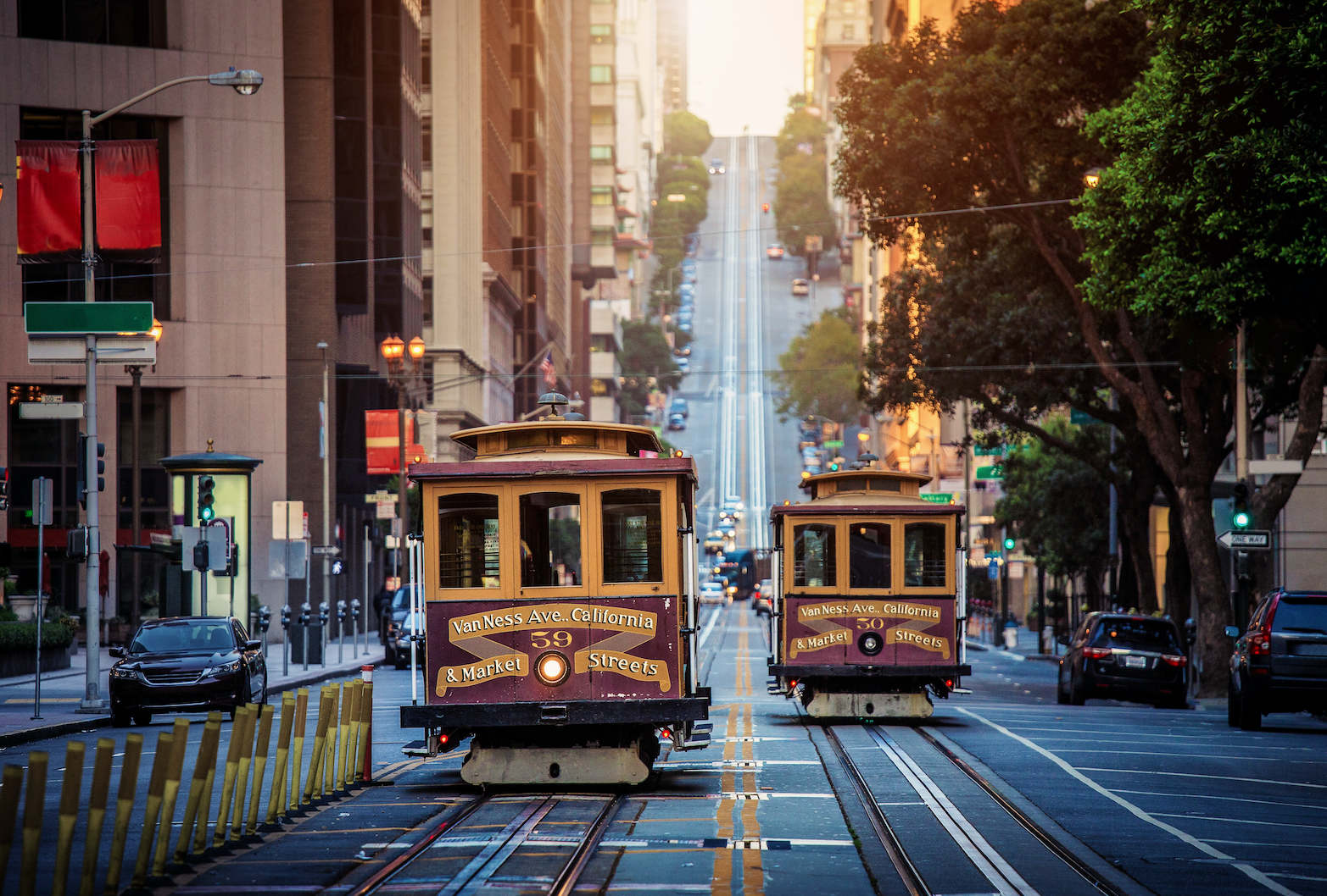 Classic view of historic traditional Cable Cars riding on famous California Street in morning light at sunrise with retro vintage style cross processing filter effect, San Francisco, California, USA